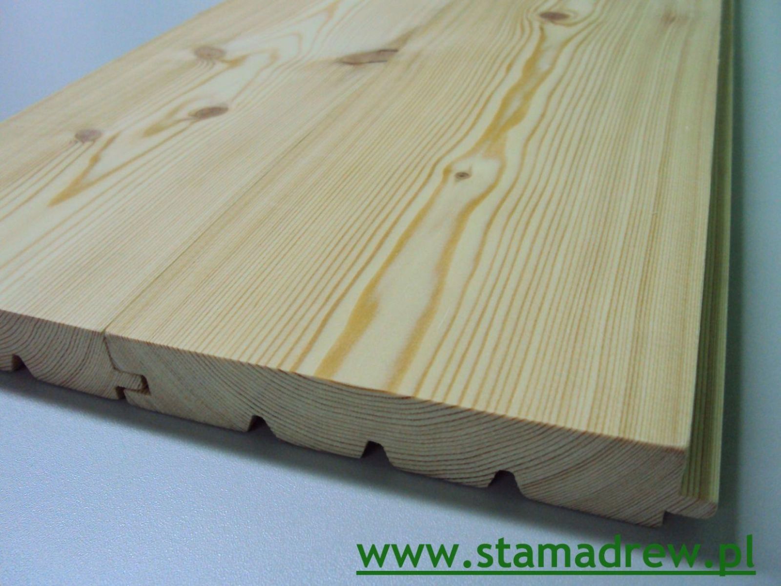 Dwa połączone panele podłogowe z jasnego drewna, widoczne słoje i system łączenia pióro-wpust.